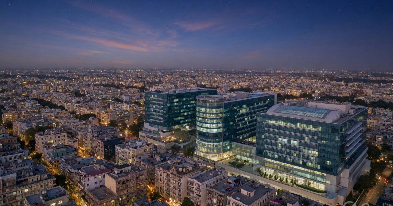 An Indian city at twilight with a modern healthcare campus in the foreground